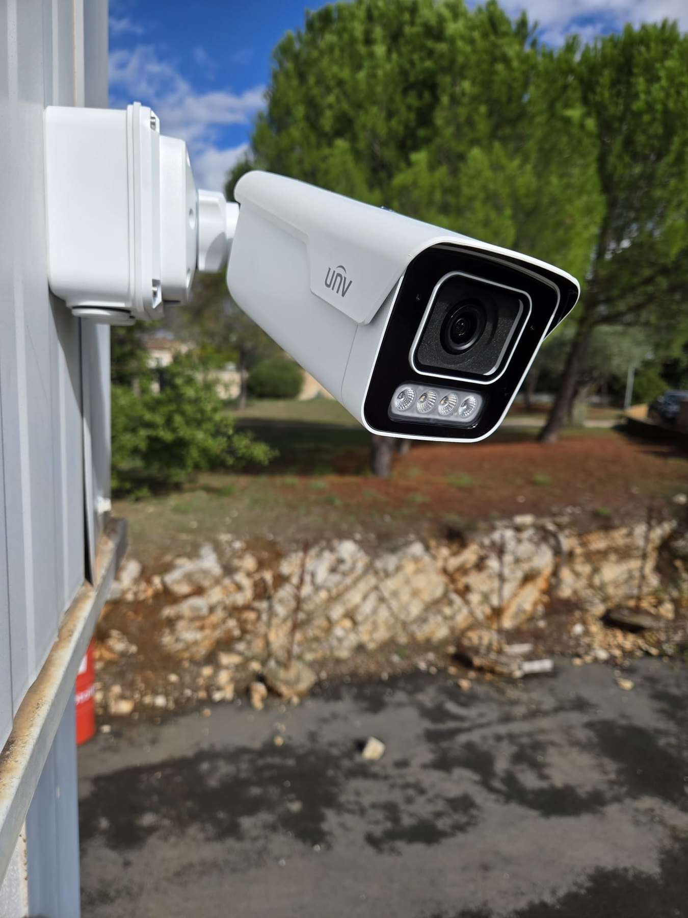 Caméra de vidéosurveillance Uniview installée sur la façade d’un garage poids lourds au Crès.