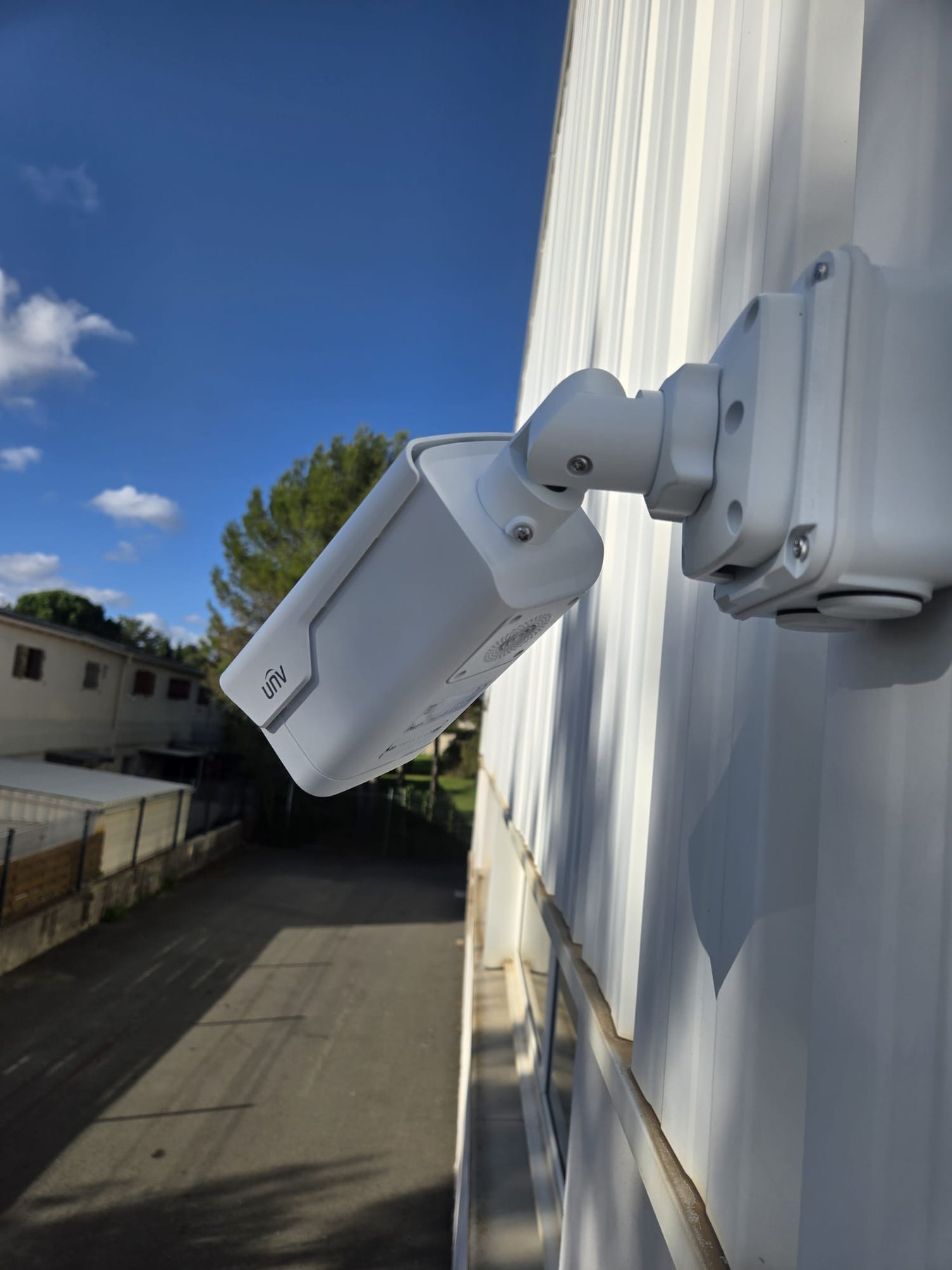 Caméra UNV fixée sur le bardage extérieur d’un atelier de maintenance de poids lourds au Crès.